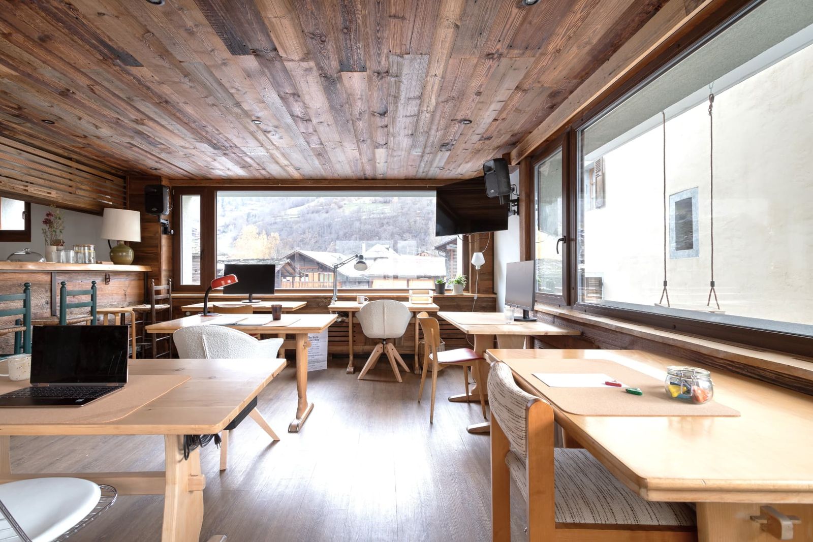 The coworking room with desks facing the village at SoHome Le Châble