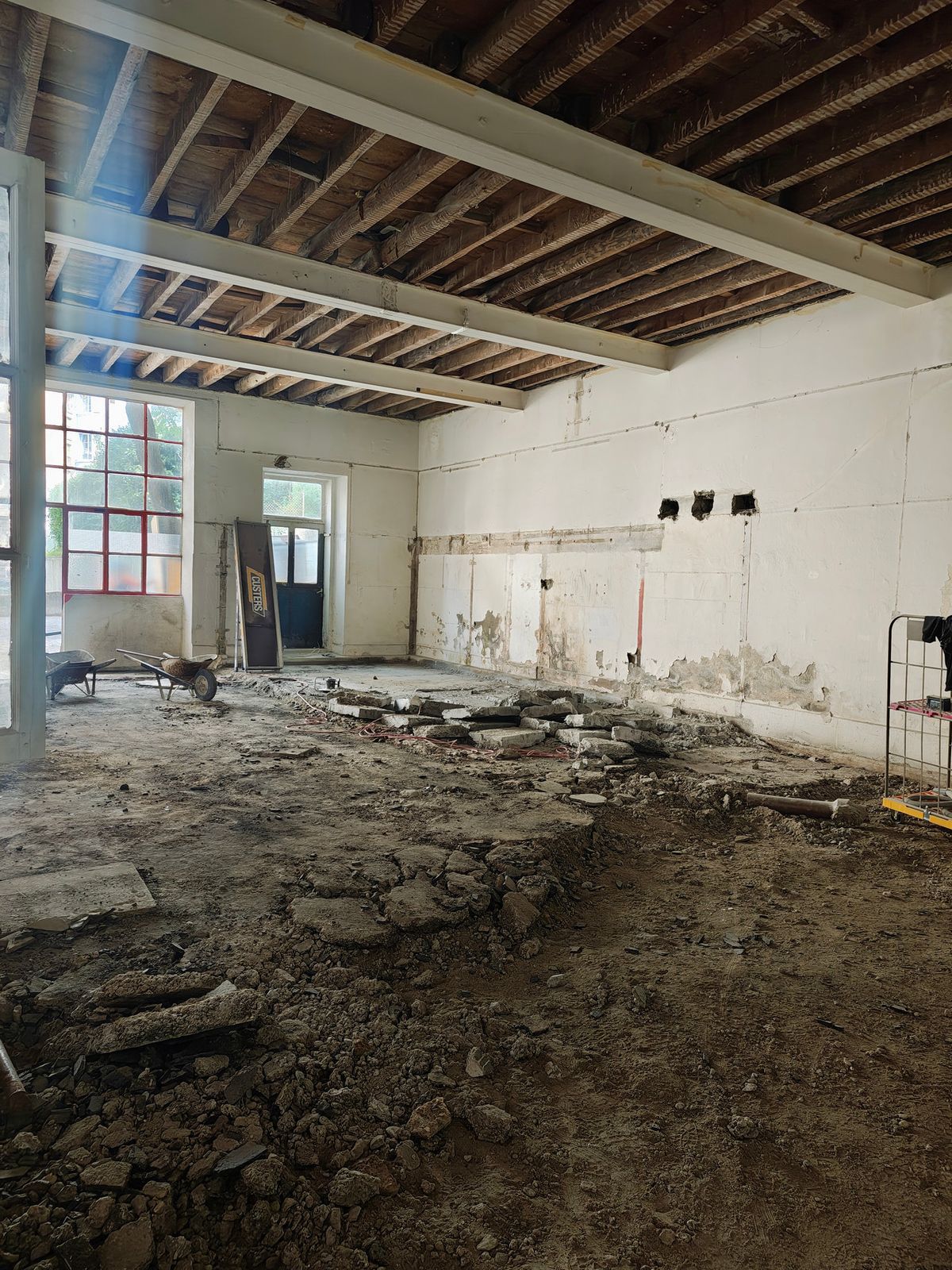 A gutted ground-floor room with stripped floor at SoHome Lausanne