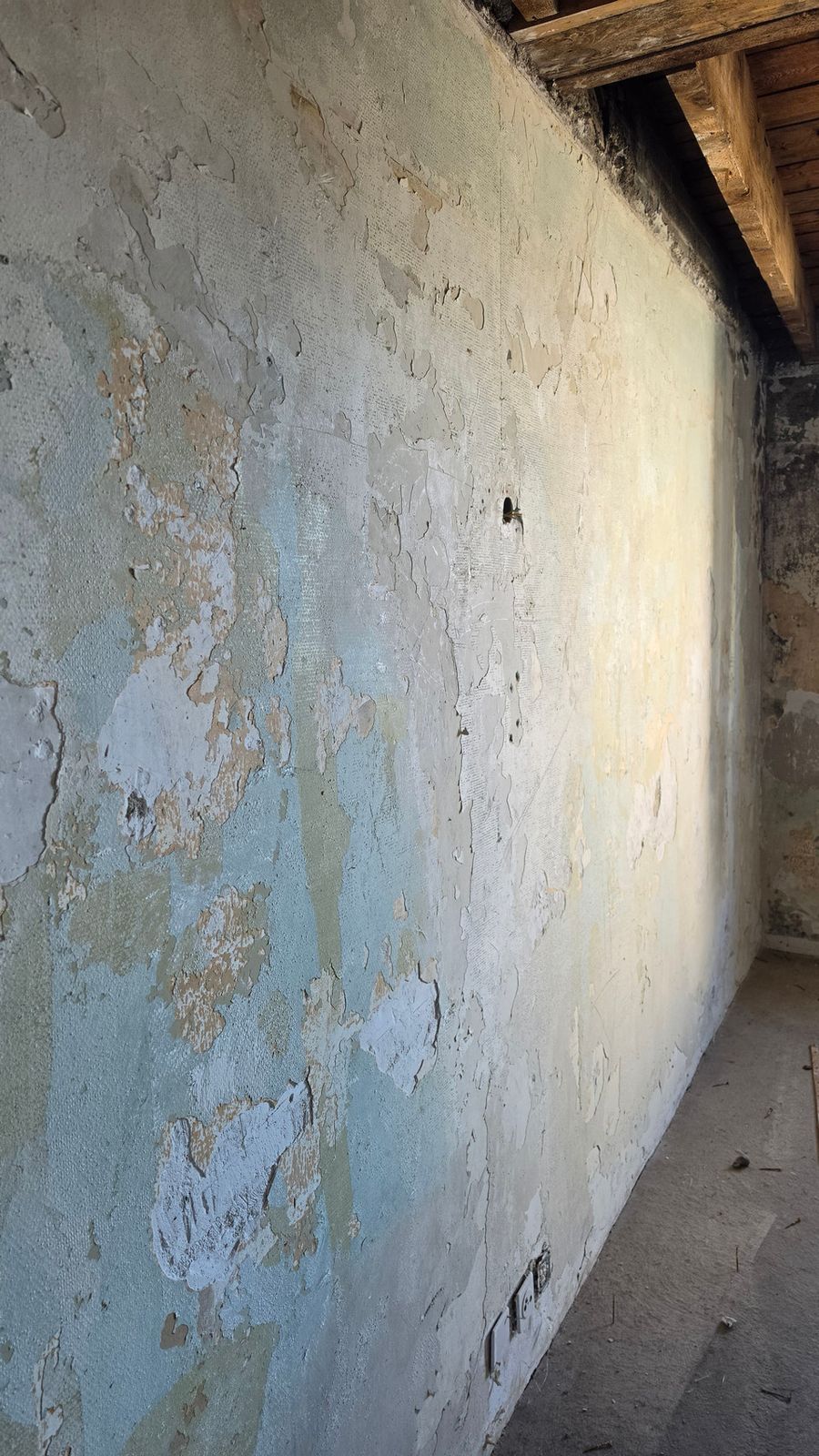 An original wall with peeling paint layers at SoHome Lausanne