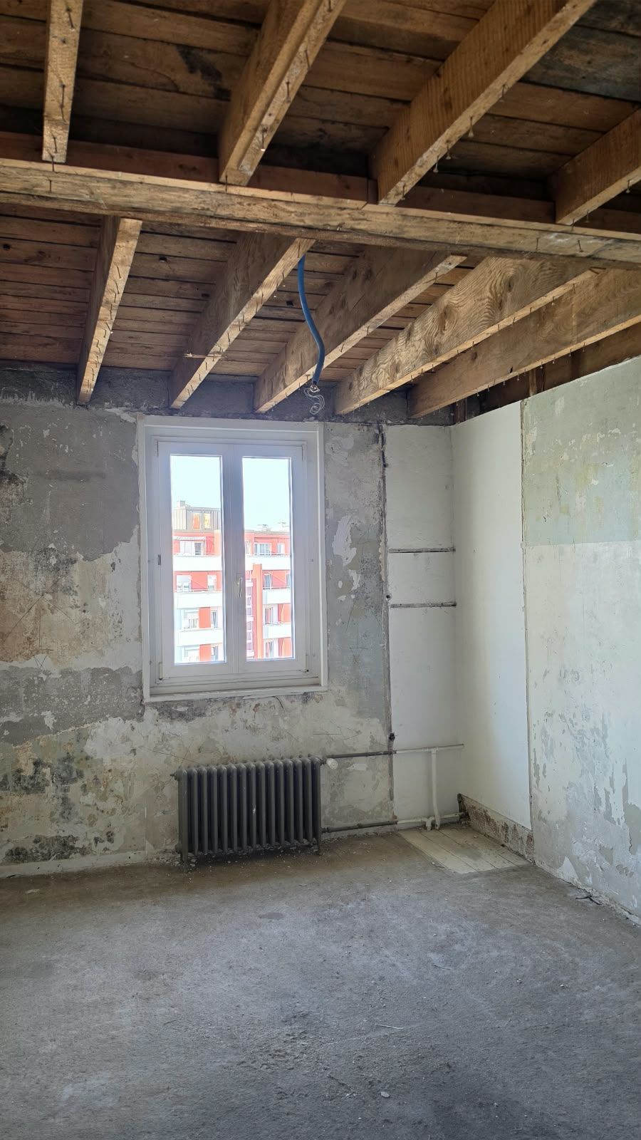 A bare room with wooden beam ceiling at SoHome Lausanne