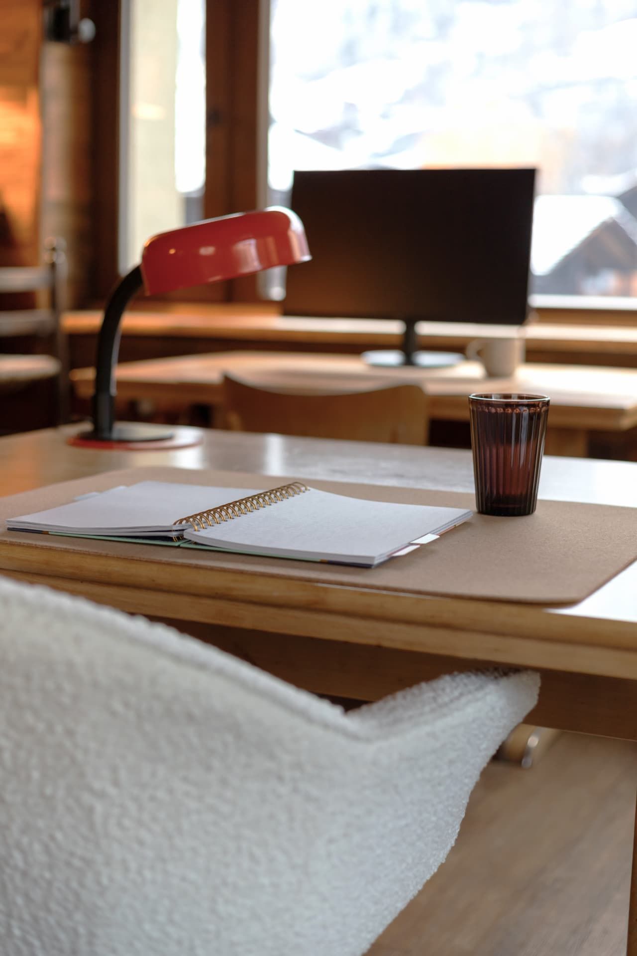 A desk with a red lamp and notebook at SoHome Le Châble