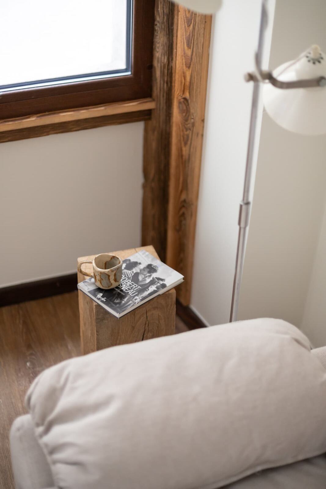 A reading corner with a book and a cup at SoHome Le Châble