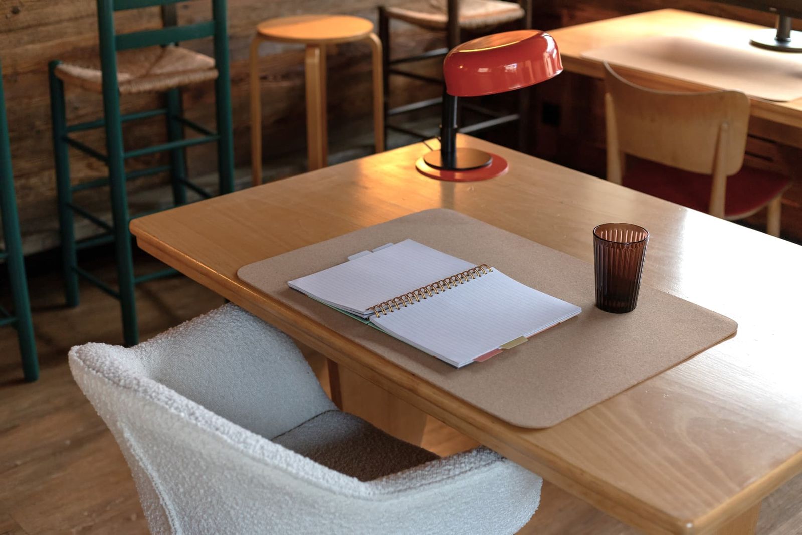 An open notebook and a glass on a wooden desk at SoHome Le Châble